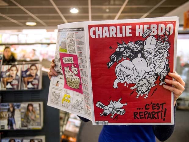 Homem lê a primeira edição do jornal 'Charlie Hebdo' lançada após os ataques de janeiro, nesta quarta-feira (25).