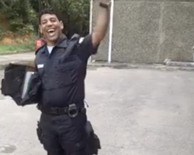 Usando a farda policial, o homem canta trechos do “Corinhos de Fogo”, de Andréa Fontes. (Foto: Reprodução/Facebook)