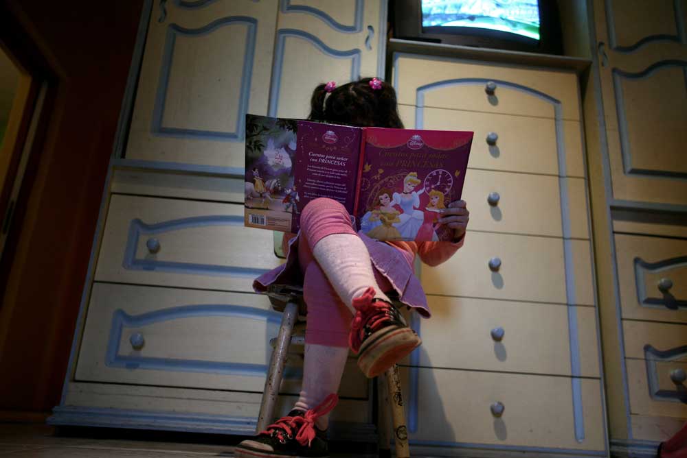 Lulu, uma 'menina' transgênero, lê um livro em seu quarto em sua casa em Buenos Aires. (Foto: Reuters)