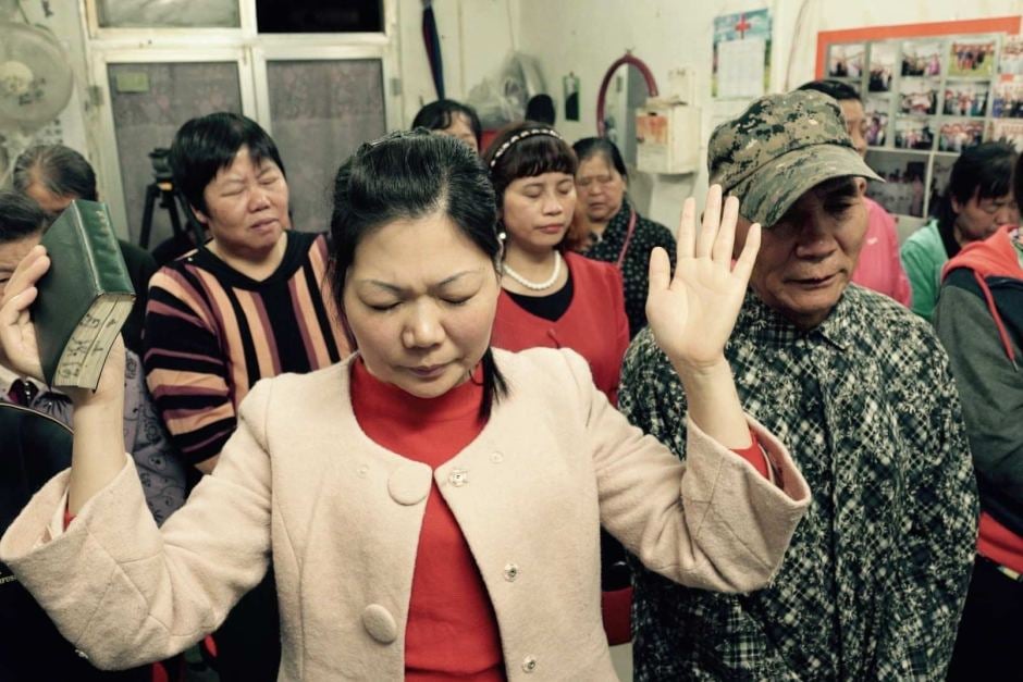 Cristãos em oração numa pequena igreja subterrânea que acontece numa loja em Pequim, na China. (Foto: Wayne Mcallister)