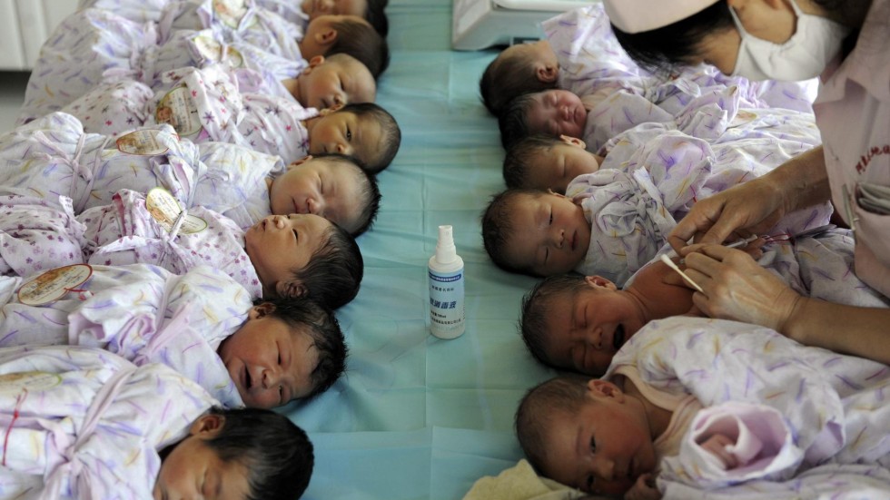 Bebês são cuidados por enfermeira na China. (Foto: South China Morning Post)