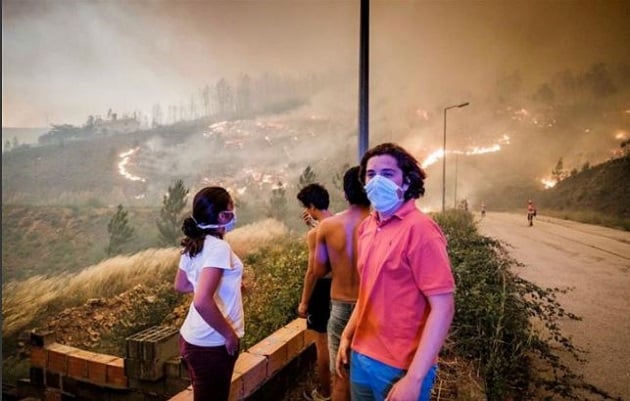 Pessoas assistem de longe às chamas se espalhando pela mata, na região de Pedrógão Grande. (Foto: Global Imagens)
