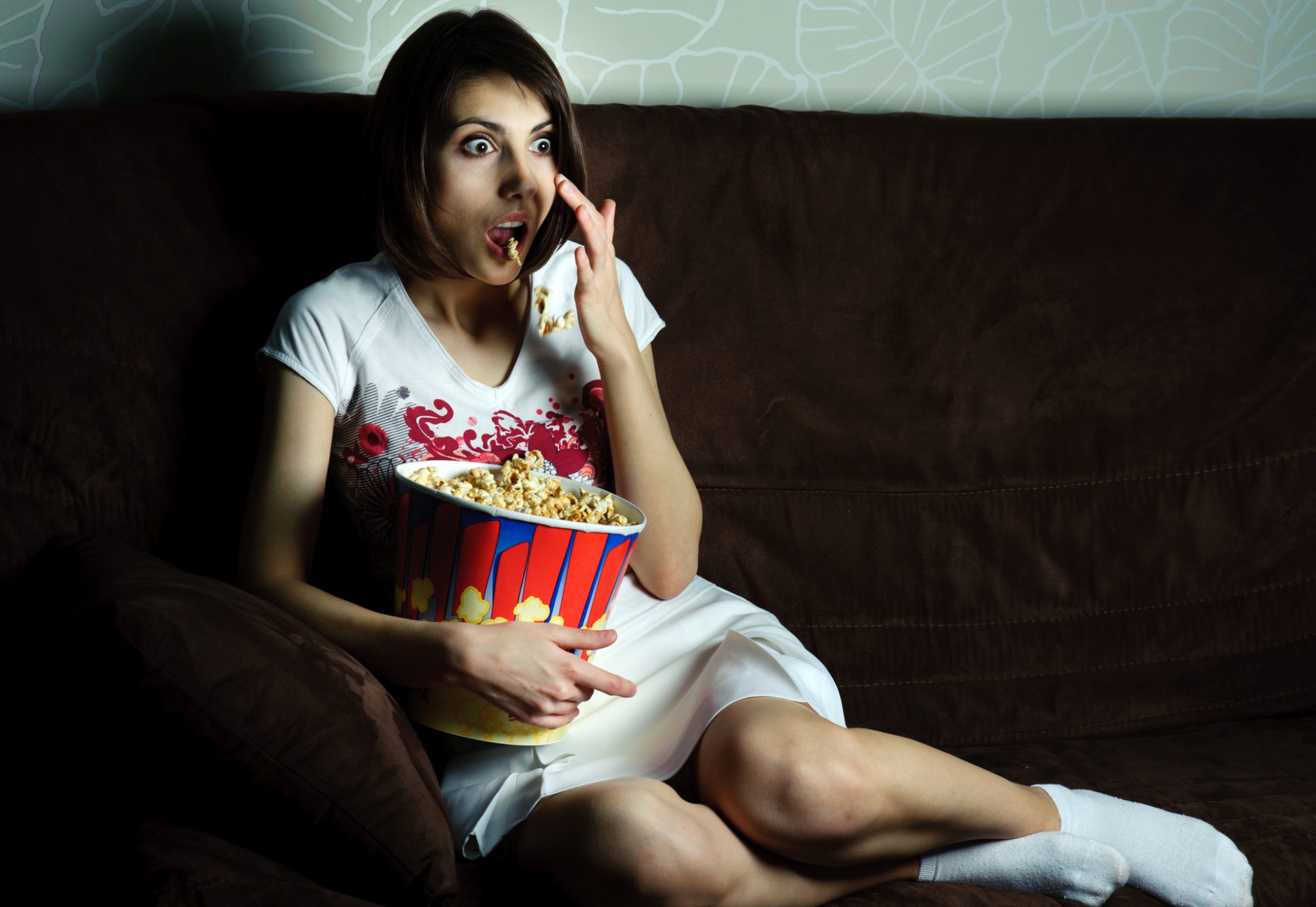 Боюсь есть вечером. Женщина перед телевизором. Девушка с попкорном. Женщина на диване с попкорном. Попкорн перед телевизором.