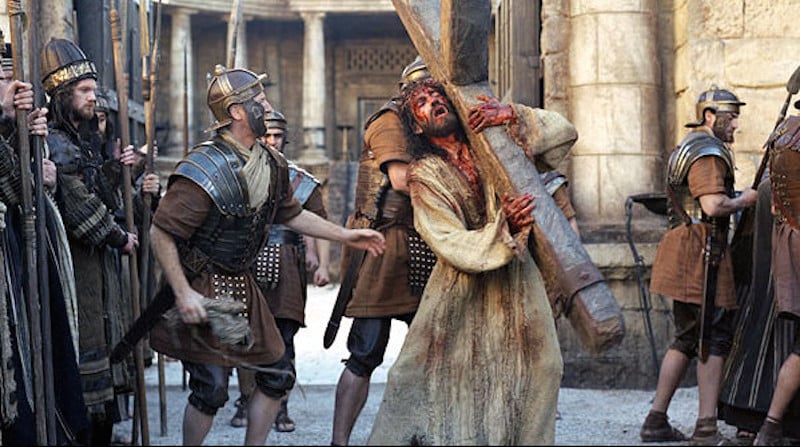 Jesus (Jim Caviezel) carrega a cruz no filme A Paixão de Cristo. (Foto: Reprodução/Icon Productions)