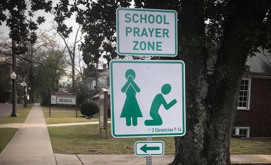 Placas com versículo bíblico convidam pais e alunos à oração. (Foto: Reprodução/CBN News)