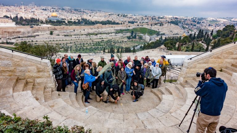 Grupo de turistas tira foto no Monte das Oliveiras, com a cidade velha de Jerusalém em segundo plano. (Foto: Shutterstock)