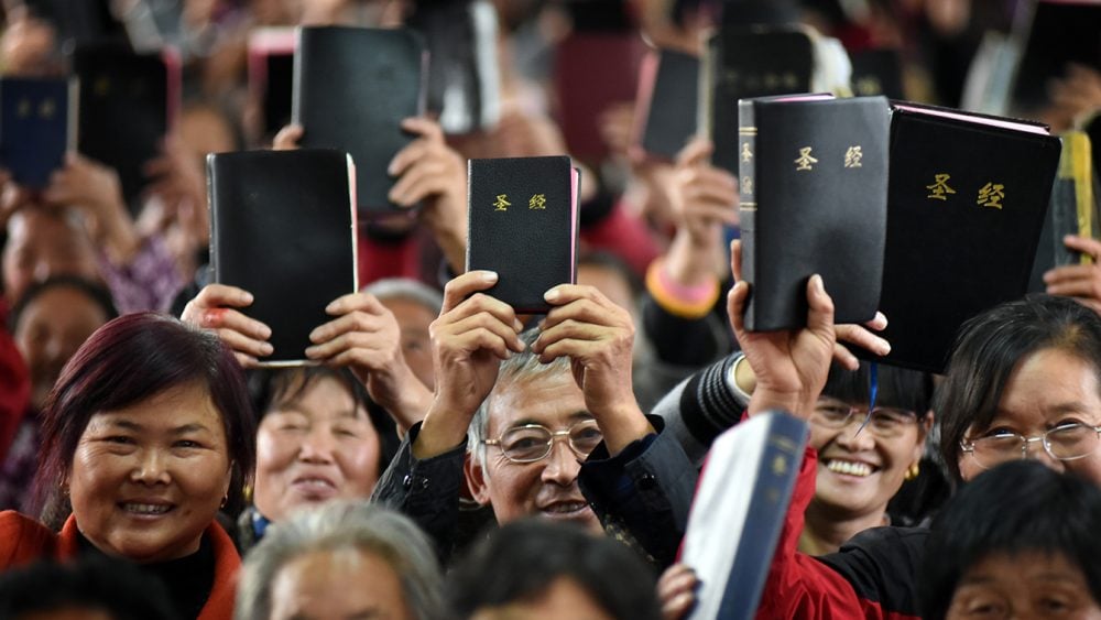 Cristãos felizes exibem suas Bíblias, na China. (Foto: Reprodução/Eternity)