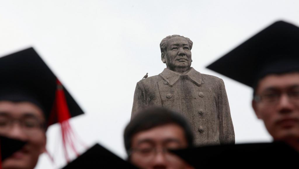 Graduados posam para foto em frente à estátua do líder chinês Mao Tsé Tung após sua cerimônia de formatura na Universidade de Fudan, em Xangai. (Foto: Aly Song/Reuters)