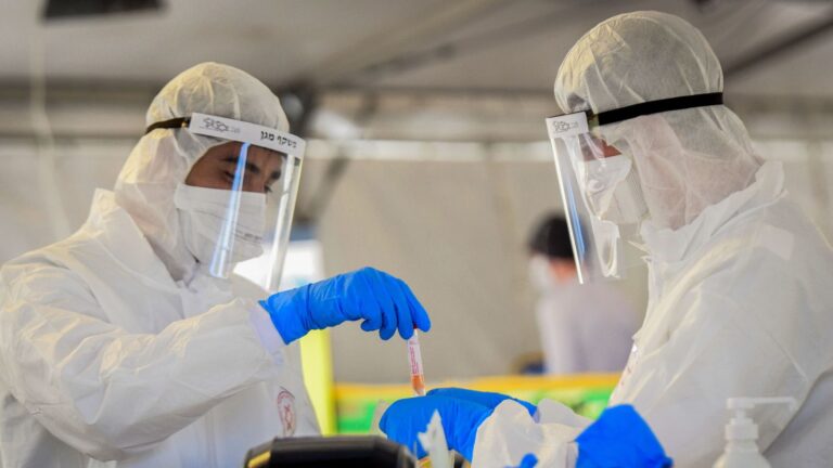 Médicos manuseiam uma amostra de teste de coronavírus em Tel Aviv. (Foto: Flash90) 