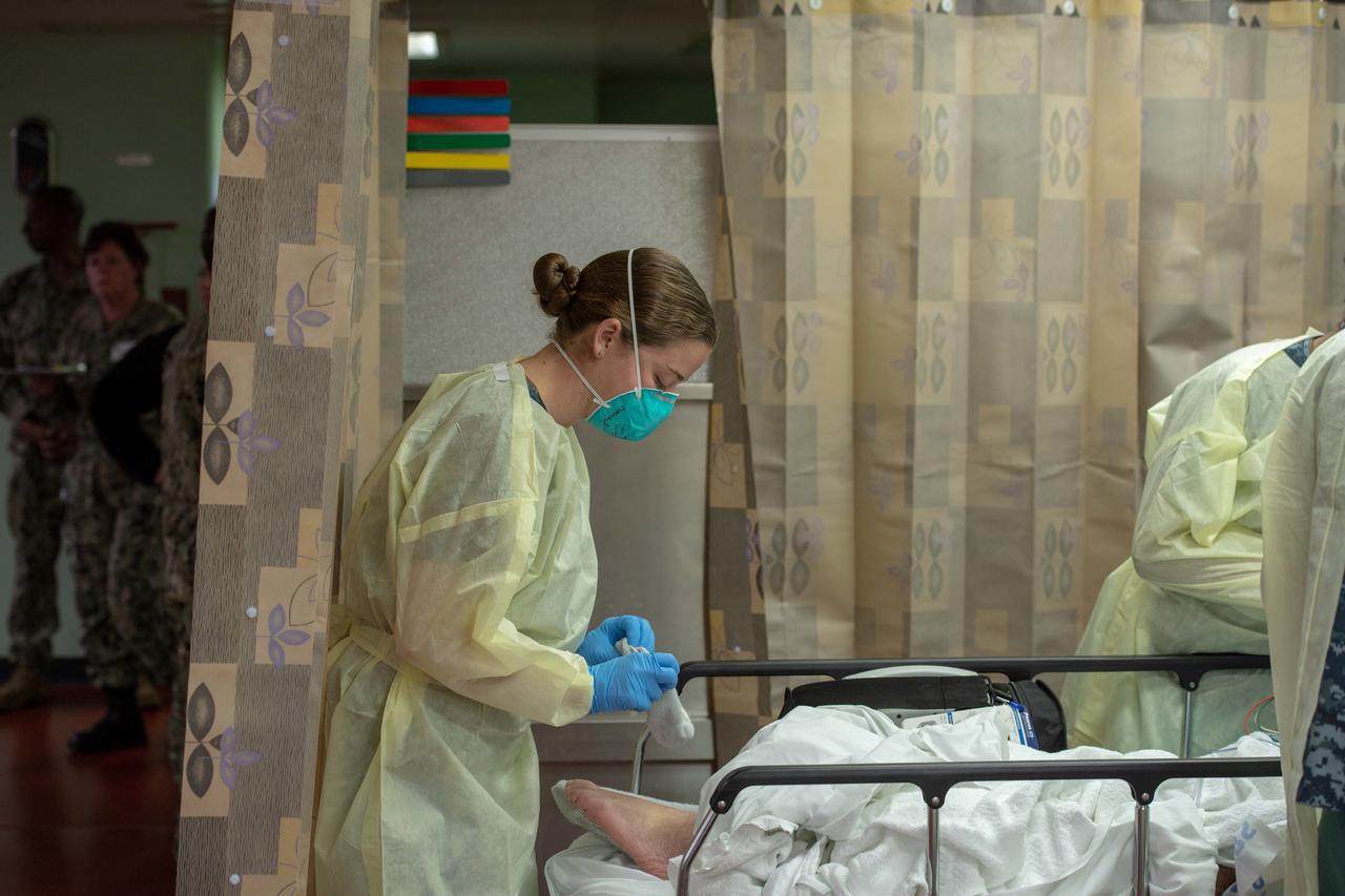Mulher trata paciente em hospital no navio USNS Mercy, implantado para tratar pacientes com Covid-19 na Califórnia. (Foto: US Navy/Erwin Jacob Miciano/Reuters)