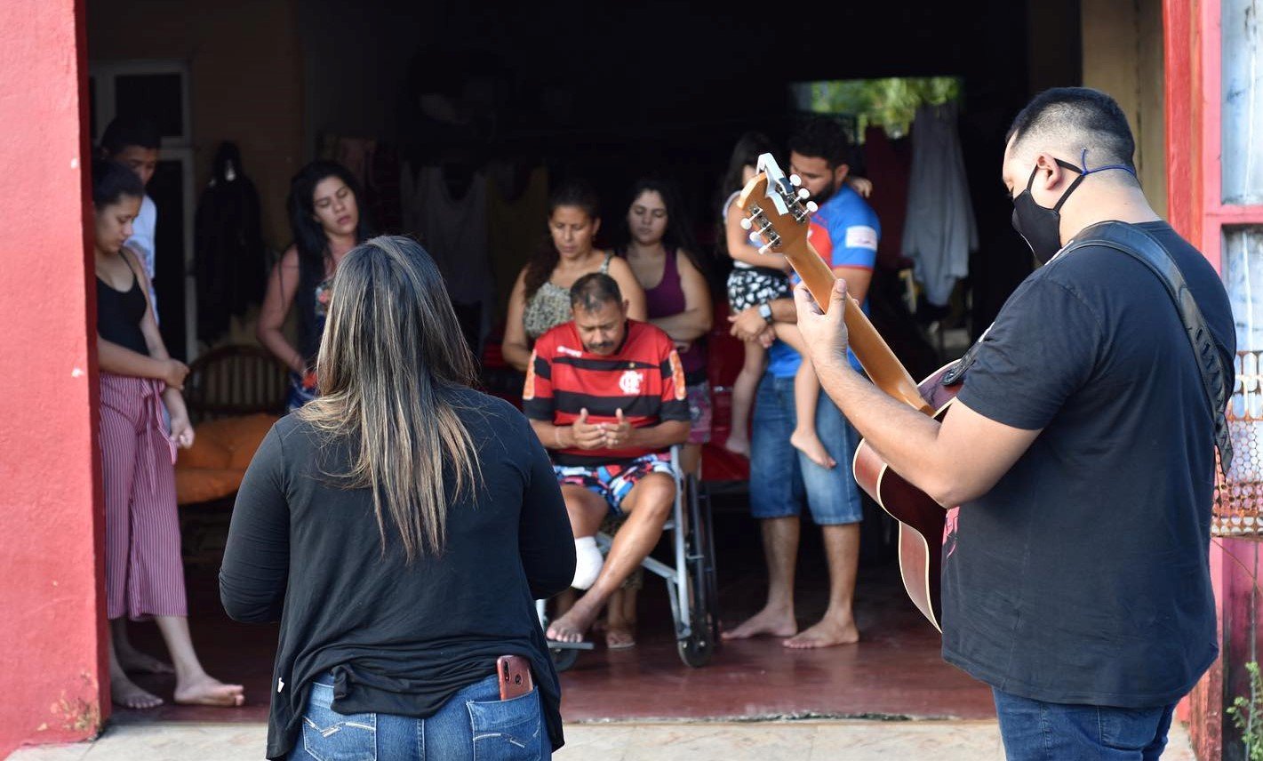 Fiéis recebem oração e louvor na porta de suas casas. (Foto: Reprodução/Facebook)