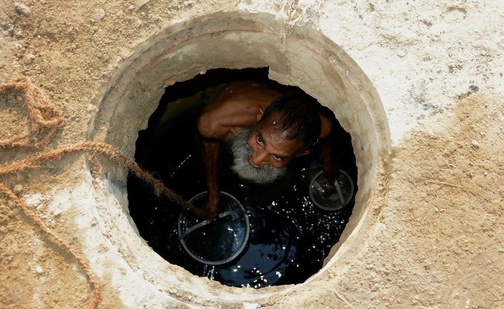 Jamshed Eric trabalhando em um esgoto em Karachi no ano passado. (Foto: Reprodução/NYT)