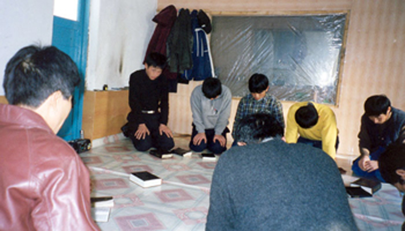 Cristãos oram ajoelhados em igreja clandestina da Coreia do Norte. (Foto: GodReports)