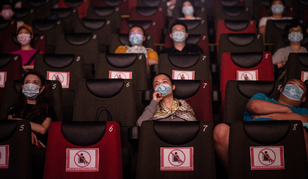 As pessoas assistem a um filme no dia 20 de julho, no primeiro dia da reabertura dos cinemas chineses em Wuhan, na província de Hubei. (Foto: Reprodução / AFP)