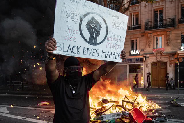 Militante do Black Lives Matter segura placa com símbolo do grupo durante manifestação violenta na França. (Foto: JULIEN BENJAMIN GUILLAUME MATTIA/ANADOLU AGENCY/GETTY)