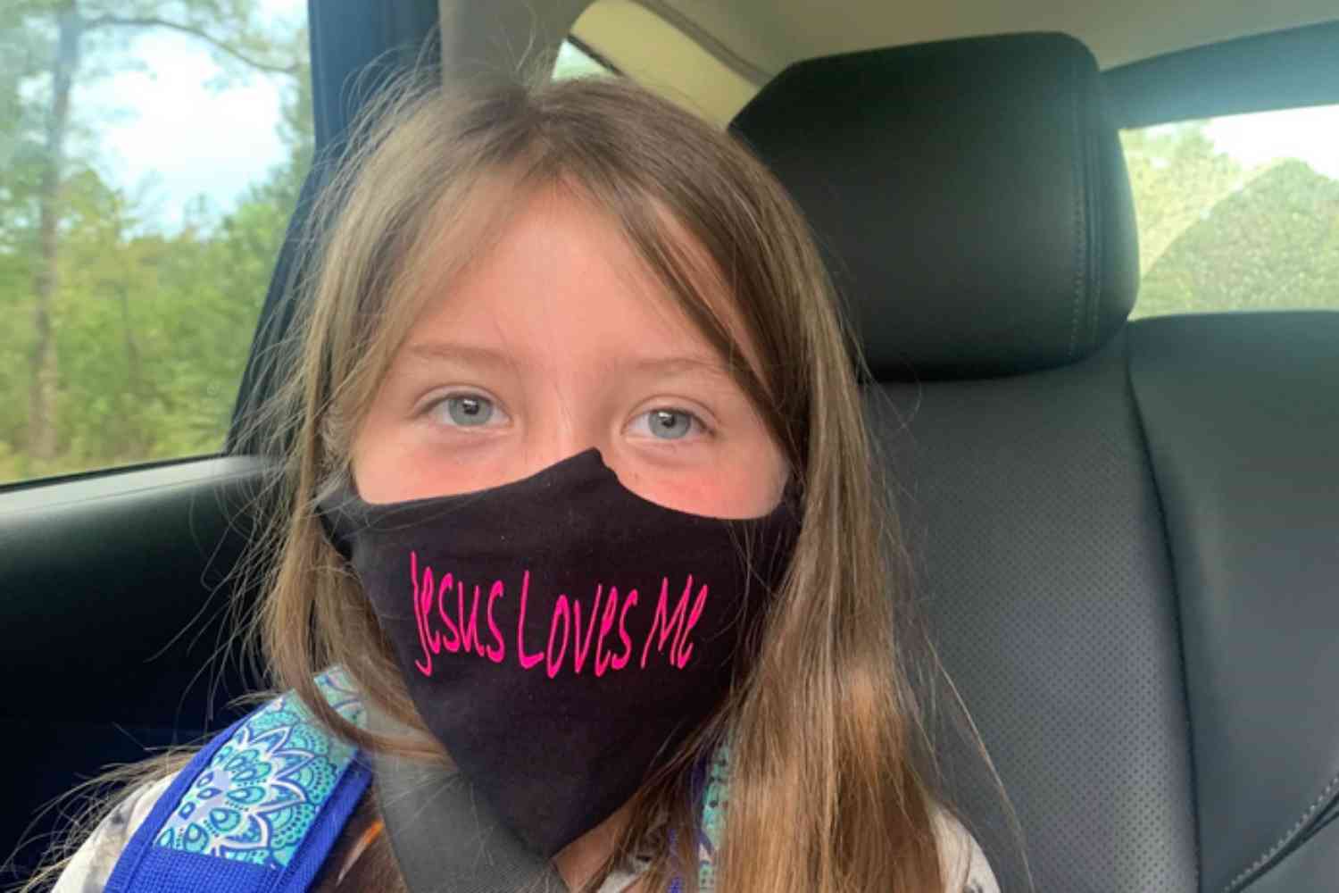 Lydia Booth foi proibida de usar sua máscara com a inscrição "Jesus Loves Me" ("Jesus me Ama") e agora sua família está processando a escola onde ela cursa a 3ª série. (Foto: Alliance Defending Freedom)