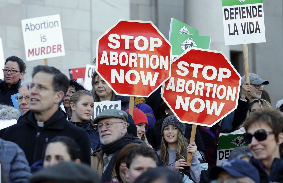 Manifestantes pró-vida protestam contra o aborto, segurando cartazes que dizem "Parem o Aborto Agora", enquanto ouvem os palestrantes em 23 de janeiro de 2017, no Capitólio em Olympia. (Foto: AP / Ted S. Warren)