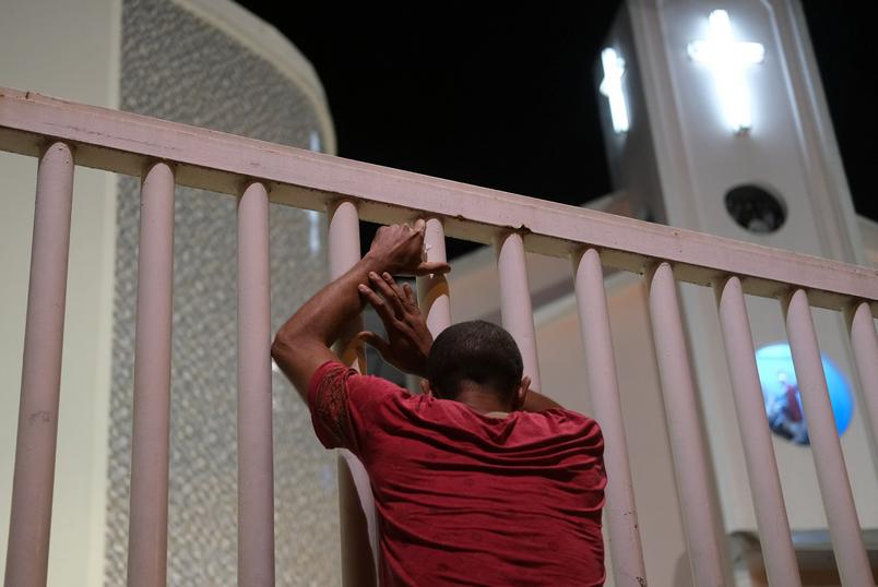 Homem do lado de fora de igreja fechada no Rio de Janeiro. (Foto: Ricardo Moraes/Reuters)
