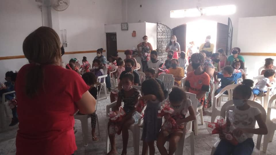 A diretora Dilene Santos ora com as crianças do Projeto Kids Crescer e Vencer. (Foto: Reprodução / Facebook)
