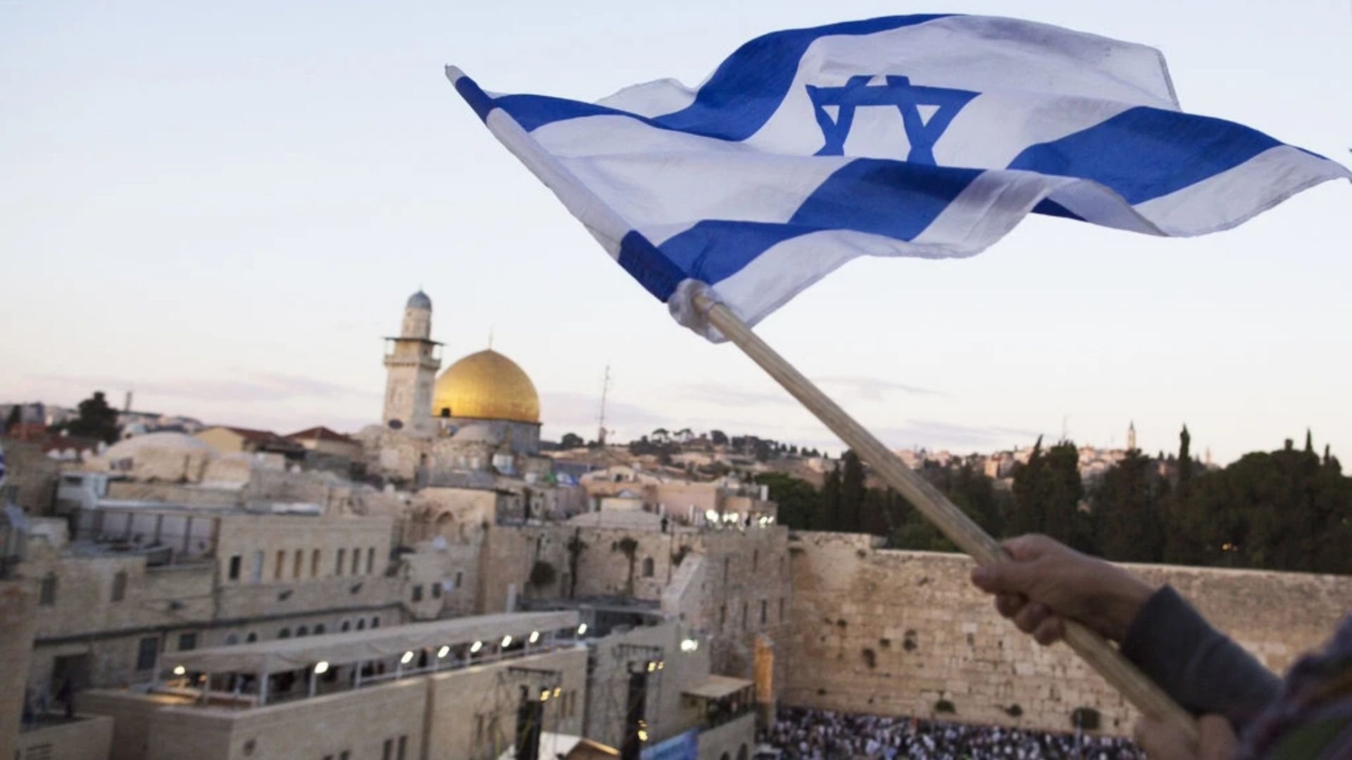 Bandeira israelense sendo hasteada perto do Muro das Lamentações no Dia de Jerusalém, em 13 de maio. (Foto: Lior Mizrahi/Getty Images)