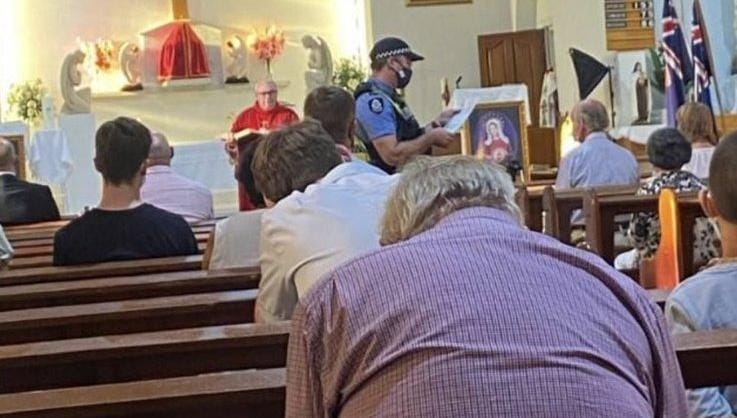Policial australiano interrompe missa para verificação do uso de máscaras. (Foto: Reprodução/7News/Patrick Horneman)
