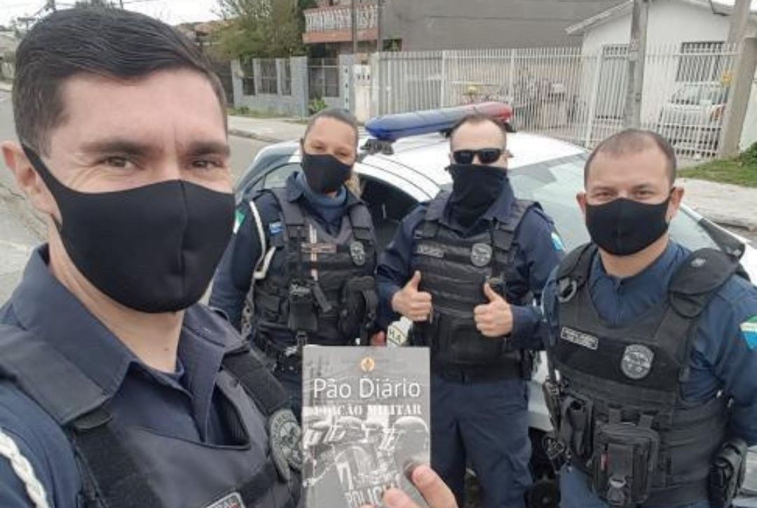 Imagem representativa de policiais segurando exemplares. (Foto: Pão Diário/Facebook)