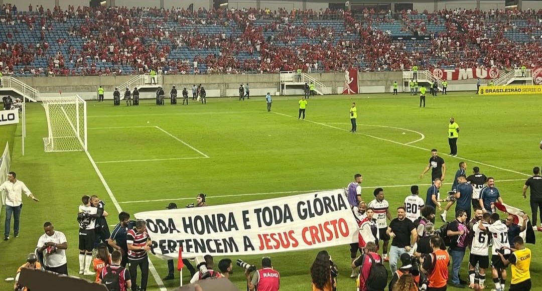 Jogadores do Santa Cruz exibem faixa ‘toda honra e glória a Jesus’ após vitória